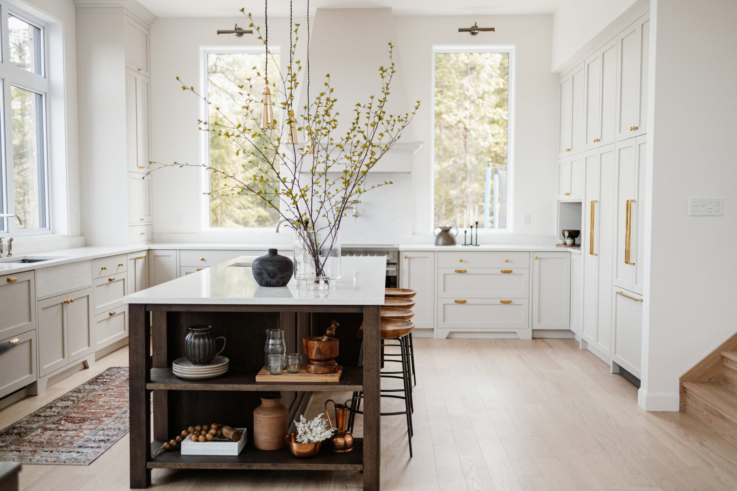 Cuisine moderne avec îlot et branches décoratives.