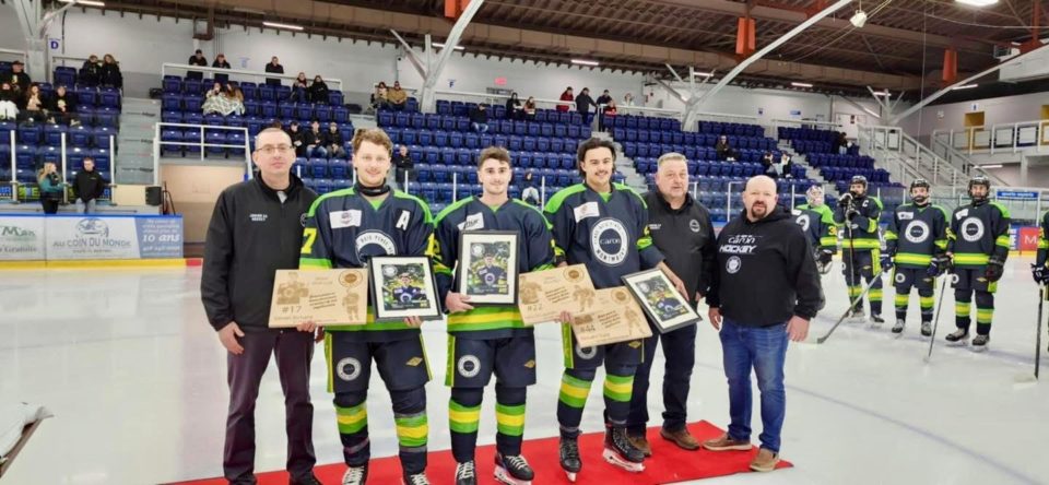 Joueurs de hockey recevant des plaques sur la glace.