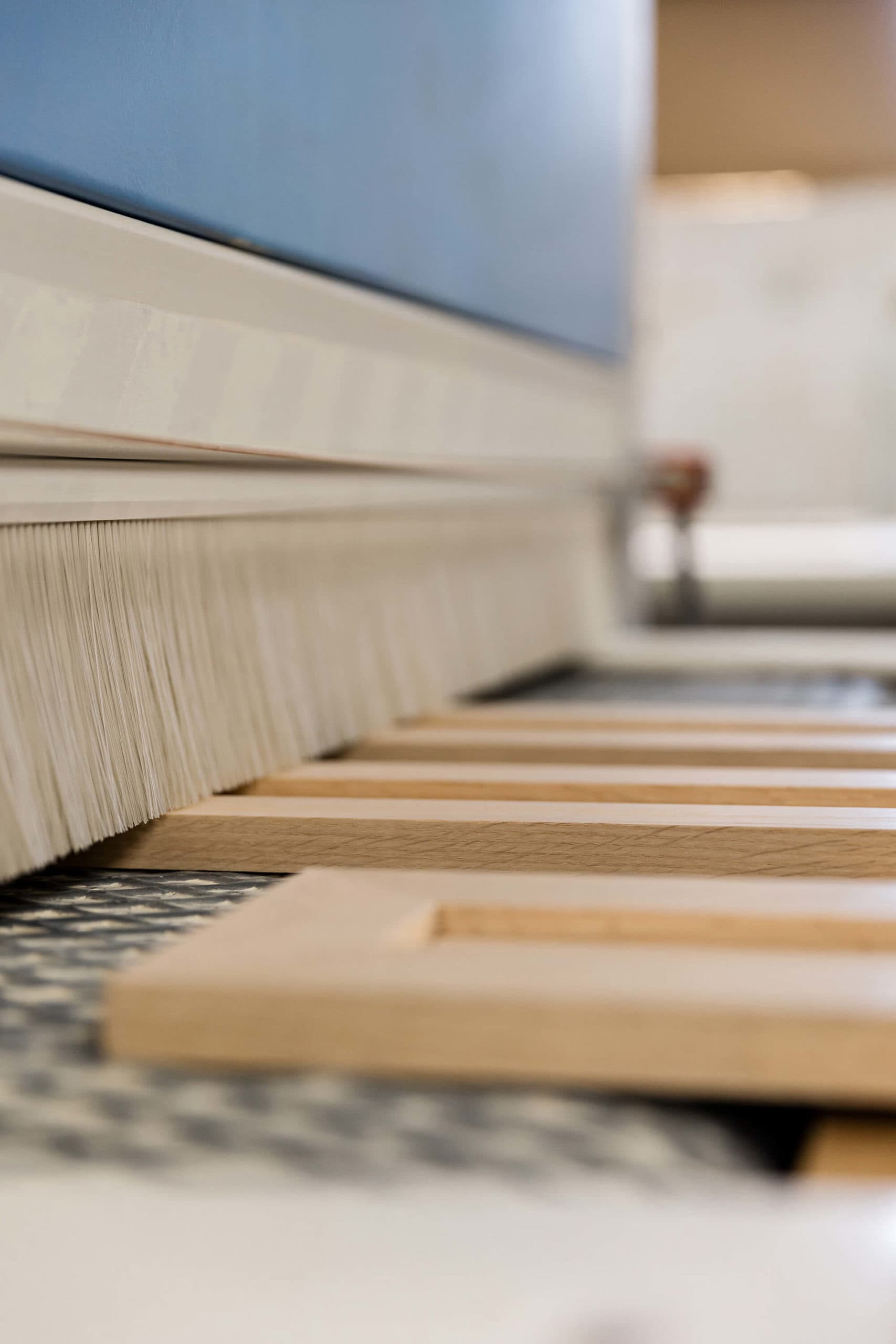 Close-up of wooden frames in sanding machine.