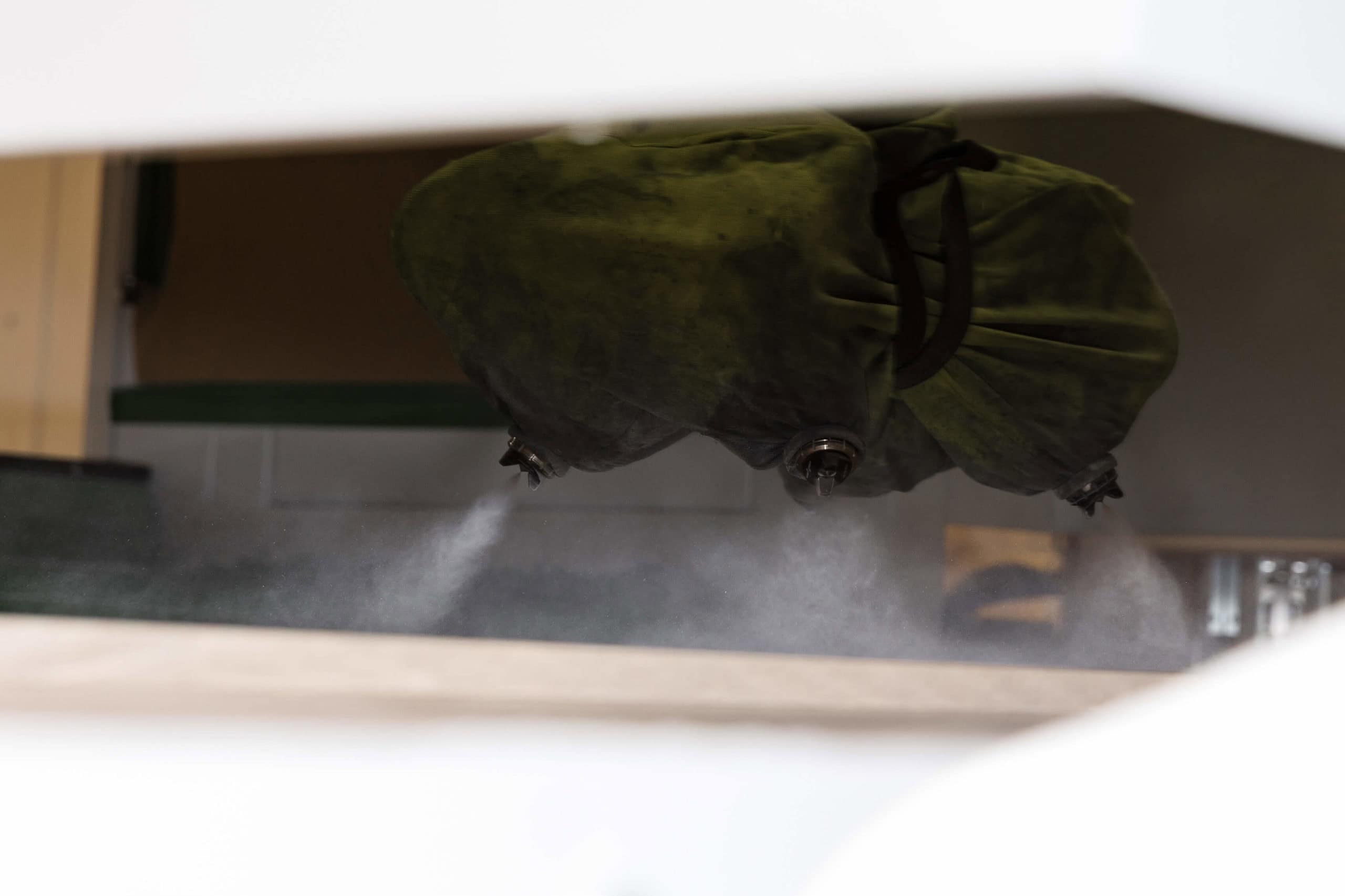 Industrial machine spraying water mist indoors.